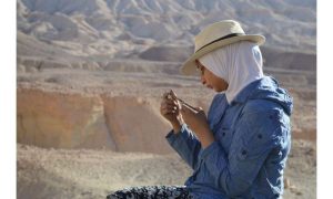 صورة: سناء السيد، المؤلفة الرئيسية للدراسة، تفحص سمكة متحجرة تم اكتشافها حديثًا في موقع قرية 3. حقوق الصورة: الأستاذ هشام سلام، مركز علم الحفريات الفقارية، جامعة المنصورة.